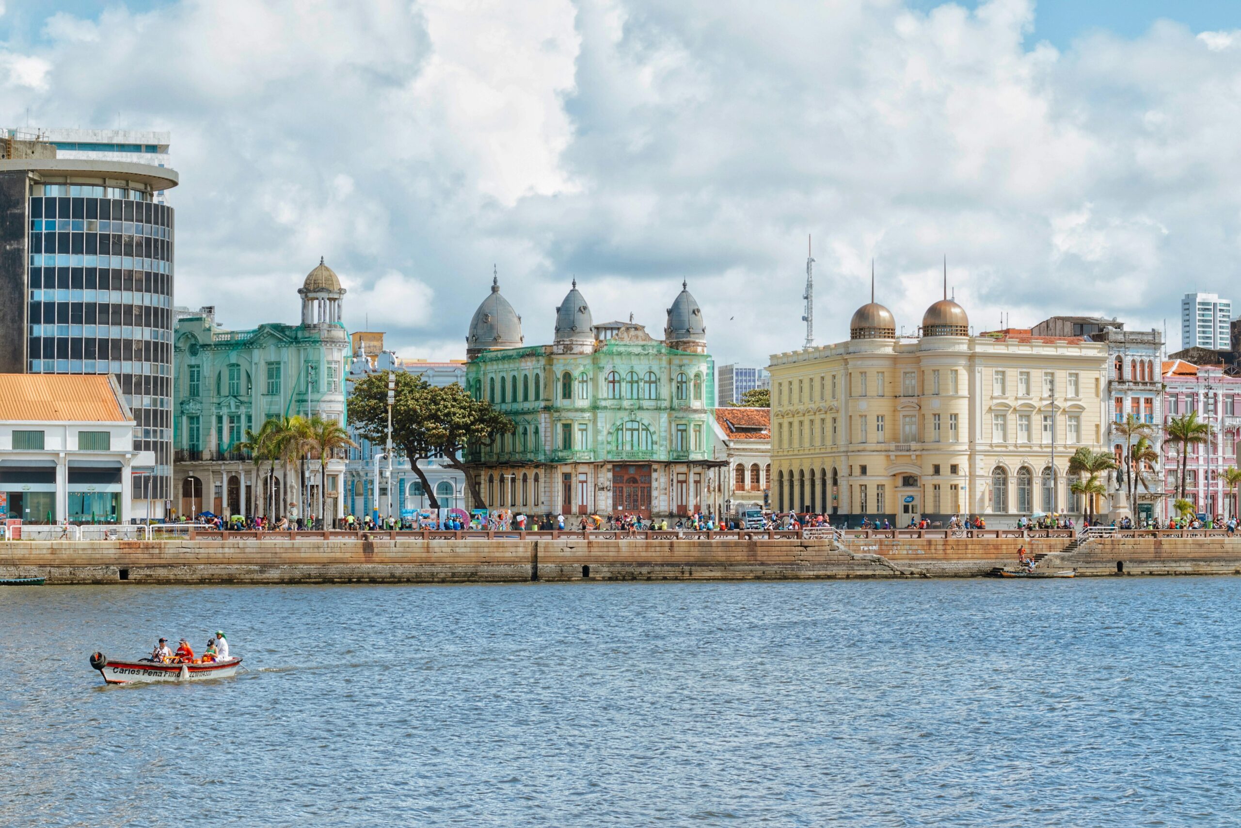 Vibrant cityscape of Recife's historic waterfront buildings under a cloudy sky.